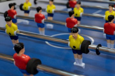 Kırmızı ve sarı oyuncularla langırt masasının yakın çekimi, detaylara odaklanıyor..