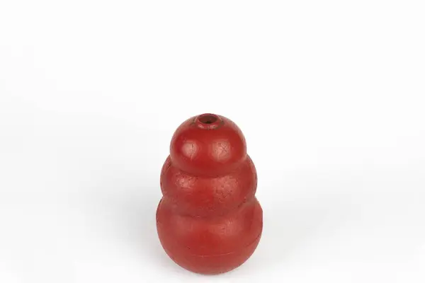 A red Kong dog toy sits on a plain white surface, a classic and durable option for canine playtime.