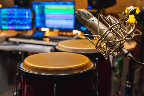 Stüdyoda büyük mikrofonları olan conga davulları. Stüdyoda perküsyon. Varilde daha yoğun mikrofonlar var..