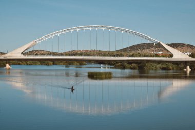 Nehirdeki bir köprü ve teknede giden bir adam.