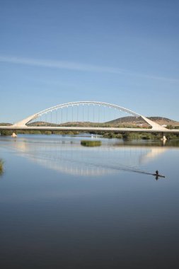 Nehirdeki bir köprü ve teknede giden bir adam.