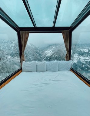 Panoramik kış manzaralı otel yatağı