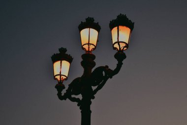 Akşamları eski bir sokak lambası parlıyor