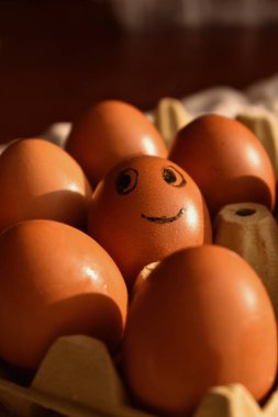 Gözleri boyalı bir yumurta ve ağzı tepsideki diğer yumurtalardan farklıdır.