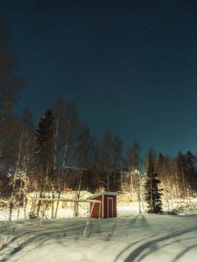 Kırmızı kulübe, ormanda, yıldızlı gökyüzünün altında Rovaniemi, Laponya 'da.