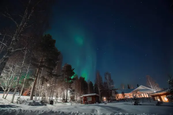 Kırmızı ahşap üzerinde Aurora Rovaniemi, Laponya 'daki karlı bahçede