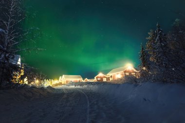 Yıldızlı gökyüzünde Aurora Rovaniemi, Laponya 'daki Noel Baba Köyü' nün üstünde.