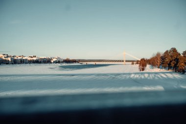 Çoğunlukla donmuş Ounasjoki nehri Rovaniemi, Laponya 'da şamdan köprüsü altında.