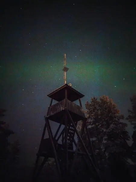 Karlı Syvasenvaara 'nın üstündeki Aurora, kışın Laponya, Rovaniemi' deki gözcü kulesi.
