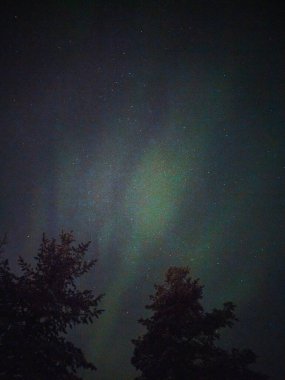 Kuzey ışıkları Rovaniemi 'nin üzerinde gece gökyüzünde, kışın Laponya' da