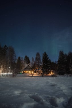 Karlı ormanda bir ev Rovaniemi 'de gece gökyüzü altında, kışın Laponya' da