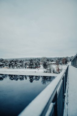 Karlı ormanın Rovaniemi 'deki nehirdeki yansıması, kışın Laponya