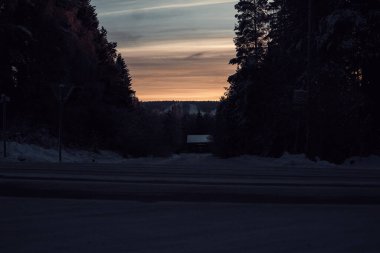 Günbatımı karlı caddenin üzerinde Rovaniemi, Laponya 'da