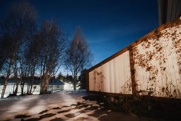 Karlı sonbahar bahçesinde gece gökyüzü Rovaniemi, Laponya