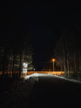 Sonbaharda geceleri, Rovaniemi, Laponya 'da ormanın içinden geçen yol.