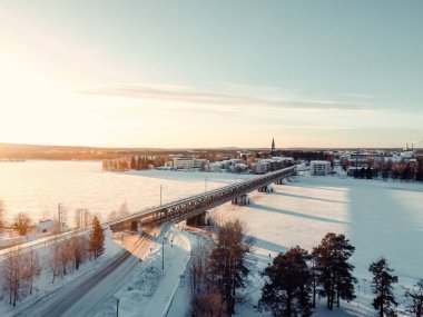 Rovaniemi, Laponya 'daki donmuş nehir üzerindeki demiryolu köprüsünün havadan görüntüsü.