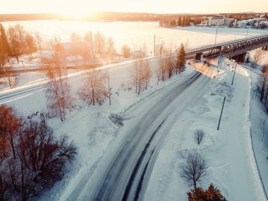 Güneş 'in Rovaniemi, Laponya' daki karlı demiryolu hattı üzerindeki hava manzarası.
