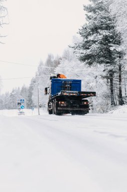 Mavi kamyon kışın karlı caddede Rovaniemi, Laponya 'da