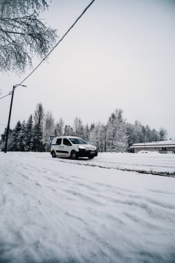 Minibüs, kışın Laponya 'da Rovaniemi' nin dışında karlı caddede ilerliyor.