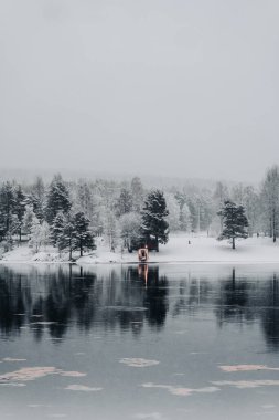 Ounasjoki nehrinin karşısındaki sauna manzaralı Rovaniemi, Laponya 'da karlı bir günde