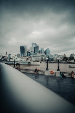 Londra, İngiltere 'deki gökdelenlerin önündeki Thames nehrindeki donanma botu.
