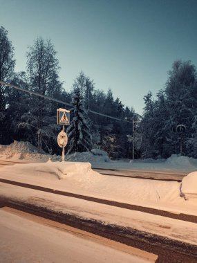 Karlı yol tabelası Rovaniemi 'de alacakaranlıkta, kışın Laponya' da