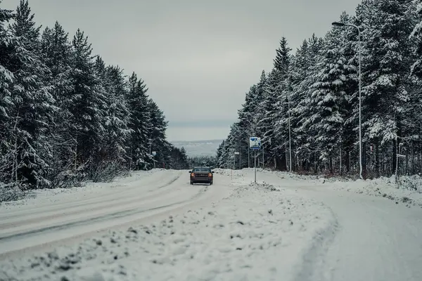 Kışın Laponya 'da Rovaniemi' nin dışında, karlı bir sokakta araba.