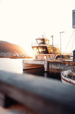 Norveç 'in Tromso limanında, Arktik fiyorttan geçen altın saat güneş ışığı