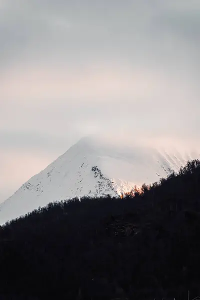 Sonbaharda Norveç 'in Tromso kentinin dışındaki kutuplarda gün batımında karlı dağ
