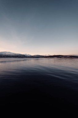 Norveç, Tromso yakınlarındaki sonbaharda günbatımında Kuzey Kutbu fiyorduna bakın.