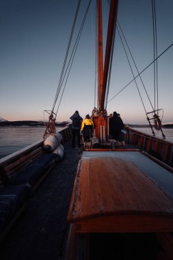 Norveç, Tromso 'da günbatımında fiyortta ahşap balıkçı teknesindeki POV