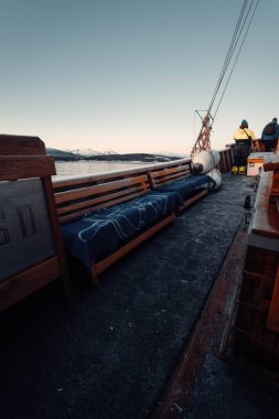 Tromso, Norveç 'te ahşap balıkçı teknesinde mavi battaniyeli banklar