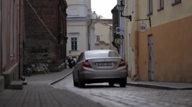 Eski kasaba Tallinn, Estonya, Rec709 4k 'de kilisenin önünden geçen araba.