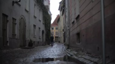 Tallinn, Estonya, Rec709 4k 'de yağmurlu yolda yürüyen bir adam var.
