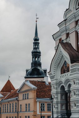 Estonya 'nın Tallinn kentindeki eski sarı binaların üzerinde kilise kulesi var.