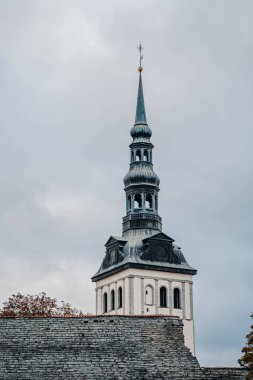 Tallinn, Estonya 'daki eski kasabanın üstündeki bulutlu gökyüzünde mavi paslanmış kilise kulesi