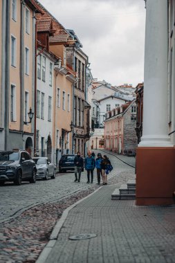 Tallinn, Estonya 'daki eski kasabada İspanyol turistler sokakta yürüyorlar