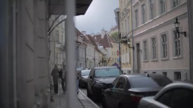 Eski kasaba Tallinn, Estonya 'da insanlar arabaların yanından geçiyorlar.