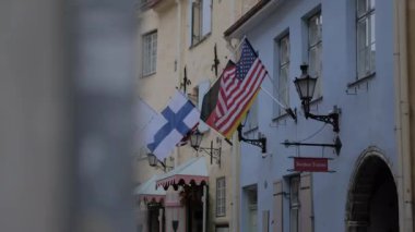 Tallinn 'deki eski kasaba sokağında bayraklar sallanıyor, Estonya