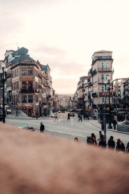 People crossing street intersection at sunset in Porto, Portugal clipart