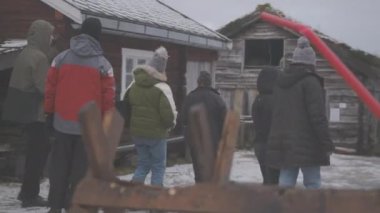 Tromso Norveç 'teki ahşap balıkçı köyünde karda rehberlik turu.