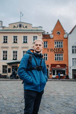 Tallinn, Estonya 'daki eski kasaba meydanında renkli binaların önünde poz veren adam