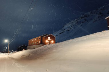 Nybyen, Longyearbyen, Svalbard 'daki karlı bir gecede ahşap bina.