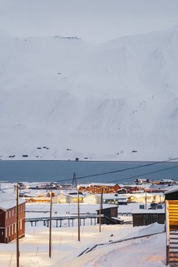 Longyear, Svalbard 'daki fiyort manzarası Nybyen' deki karlı yolda.