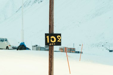 Longyear 'daki Gjestehuset 102 tahta tabela direği, Kuzey Kutbu' ndaki Svalbard