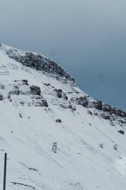 Longyear, Svalbard Kuzey Kutbu 'ndaki karlı dağ boyunca uzanan hava madencilik kablosu