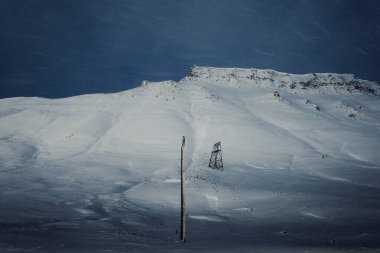 Longyear, Svalbard 'daki karlı dağda ahşap kablo kulesi.