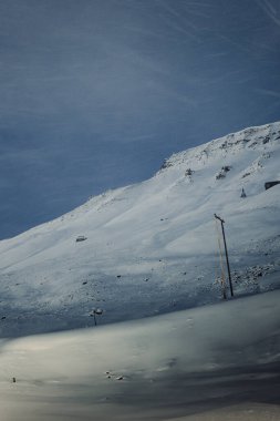 Longyearbyen, Svalbard 'daki karlı dağda elektrik hatları