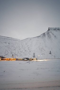 Longyear byen, Svalbard karlı dağları ve arkasında maden kablosu olan