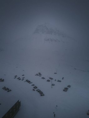 Snowmobiles parked in the snow under Sarkofagen in Longyearbyen, Svalbard clipart